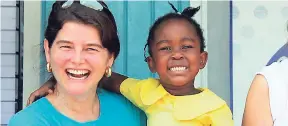  ??  ?? Samantha Mahfood, executive director of Food For The Poor Canada, smiles joyfully with one of the young students at a school in Jamaica.