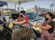  ?? Irfan Khan Los Angeles Times ?? MAYRA RUIZ, left, and her mother, Adela, prepare fresh tortillas for their tacos de chile relleno at MidCity Cookouts in Arlington Heights on Saturday.