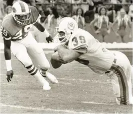  ?? SOUTH FLORIDA SUN SENTINEL FILE ?? Miami Dolphins fullback Larry Csonka falls to the ground with the ball during a game against the Buffalo Bills.