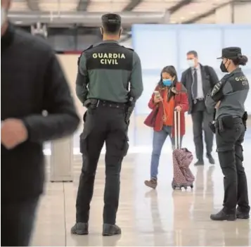  ??  ?? La Guardia Civil, ayer en la terminal de llegadas del aeropuerto madrileño