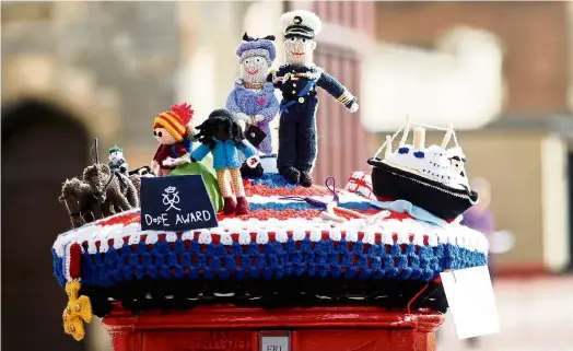  ?? — Reuters ?? Royal memento
Knitted figures of Britain’s Queen Elizabeth and Prince Philip are pictured on top of a letter box in Windsor, near London.