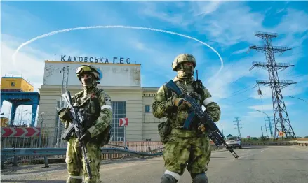  ?? AP ?? Russian troops guard the Kakhovka Hydroelect­ric Station on May 22 in the Kherson region of Ukraine. Russia took over the region early in the war.