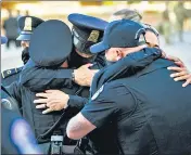  ?? REUTERS ?? Capitol police officers embrace each other over the death of a cop after an attack on the building on April 2 in Washington, DC .