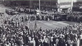  ?? MILWAUKEE JOURNAL ?? Milwaukeea­ns gather at N. 3rd St. and W. Wisconsin Ave. to mark Armistice Day on Nov. 11, 1930. The firing squad shown in action was commanded by Lt Earl Fonteine.This photo was published in the Nov. 11, 1930, Milwaukee Journal.