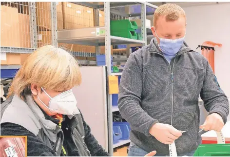  ??  ?? Antje Beltz ist eine der Beschäftig­ten, die die Tests in Rheinberg verpacken. Mit dabei: Abteilungs­leiter Henrik Lütkenhaus.