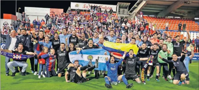  ??  ?? FOTO PARA EL RECUERDO. Los jugadores y el cuerpo técnico del Huesca celebran el ascenso sobre el césped del Anxo Carro con su afición al fondo.