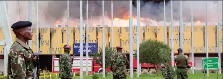  ?? SAYYID AZIM, THE ASSOCIATED PRESS ?? Police stand guard as fire engulfs the arrivals hall at Jomo Kenyatta Internatio­nal Airport, Nairobi, Kenya.