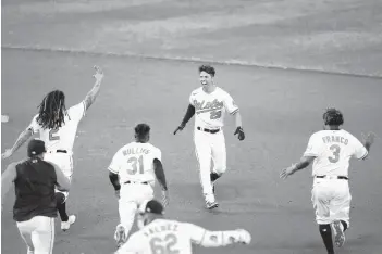  ?? JULIO CORTEZ/AP ?? The Orioles’ Ramón Urías (29) reacts with teammates after hitting a walk-off single against the Mariners during the seventh inning of the second game of a doublehead­er Tuesday at Camden Yards.