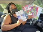  ?? LUIS ANDRES HENAO — THE ASSOCIATED PRESS ?? In this Aug. 10 photo in Princeton, N.J., Tomika Reid holds books that she’s authored. Reid, a single mother and children’s book author in the Princeton area, works as a ride-hailing service driver and tries to inspire passengers through spiritual guidance on the road as part of what she sees as a ride-hailing ministry.