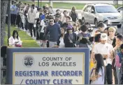  ?? MARK J. TERRILL— THE ASSOCIATED PRESS FILE ?? Potential voters wait in long lines to register and vote at the Los Angeles County.