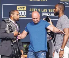  ?? JOHN LOCHER/ASSOCIATED PRESS ?? Dana White, center, stands between Daniel Cormier, left, and Jon Jones during a news conference last year.