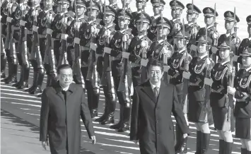  ?? ASSOCIATED PRESS ?? Japanese Prime Minister Shinzo Abe, right, and Chinese Premier Li Keqiang review an honor guard during a welcome ceremony at the Great Hall of the People in Beijing.