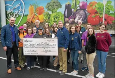  ?? PETE BANNAN — DIGITAL FIRST MEDIA ?? Downingtow­n and Malvern Wegmans Food Markets employees present Chester County Food Bank executive director Larry Welsch, center with a check for $152,789 and a truckload of nearly nine tons of non-perishable food. The money was raised during Wegmans’ Care About Hunger campaign, during which customers were asked if they would contribute $1 to $5 or any other amount at checkout, with all the proceeds going to the local food bank.