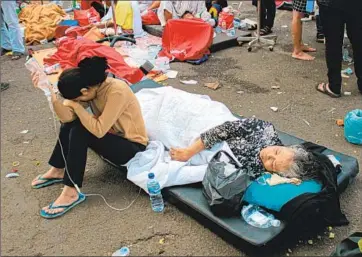  ?? Kholid Associated Press ?? INJURED PEOPLE get medical aid outside a full hospital after a powerful earthquake in Cianjur in Indonesia’s West Java province. Many of those killed were students at Islamic schools that collapsed in the quake.