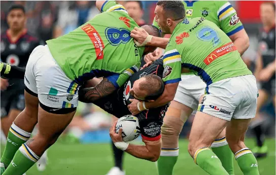  ?? PHOTO: PHOTOSPORT ?? Simon Mannering is wrapped up by several Canberra players during the Warriors’ latest loss in the NRL in Auckland yesterday, beaten 36-16 by the Raiders.