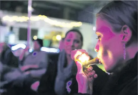  ?? Brennan Linsley Associated Press ?? LAW ENFORCEMEN­T officials say pot lounges could lead to more intoxicate­d driving. Above, a woman smokes in Denver in 2012.