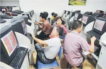  ??  ?? Investors chat in front of computer screens showing stock informatio­n at a brokerage house in Qingdao, Shandong province, China. China stocks jumped more than 4 percent on Monday on possible restructur­ing among major shipping firms and in other key...
