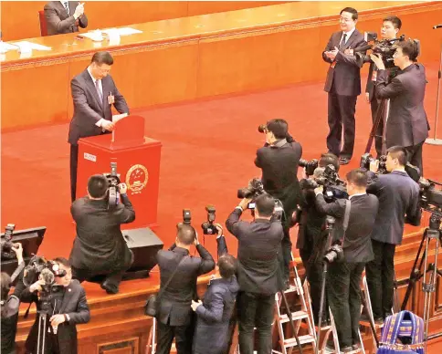  ??  ?? Xi casts his ballot during a vote on a constituti­onal amendment lifting presidenti­al term limits, at the third plenary session of the National People’s Congress (NPC) at the Great Hall of the People in Beijing. — Reuters photo