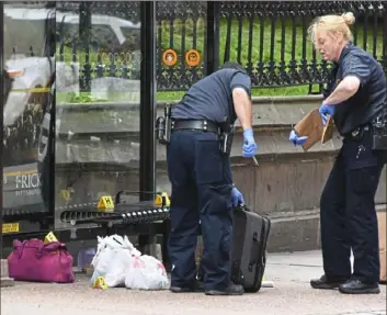  ??  ?? Pittsburgh police officers collect evidence Thursday afternoon at the scene of the stabbing.