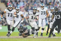  ?? Tim Ireland, The Associated Press ?? Philadelph­ia Eagles quarterbac­k Carson Wentz scrambles for yardage Sunday at Wembley Stadium in London.