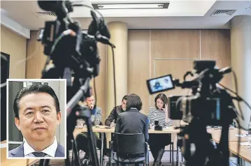  ?? — AFP photo ?? Grace, the wife of Meng (inset), talks to journalist­s in Lyon during a press conference during which she did not want her face to be shown.
