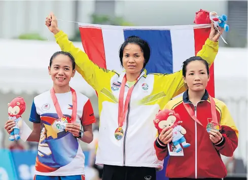  ?? REUTERS ?? Natthaya Thanaaronn­awa, centre, celebrates on the podium after winning the women’s marathon.