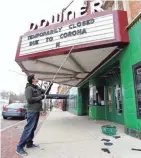  ?? MIKE DE SISTI / MILWAUKEE JOURNAL SENTINEL ?? Rashad Kraima, Landmark Downer Theatre general manager, changes the movie theater’s marquee to reflect the new normal for theaters in the coronaviru­s pandemic. The Downer closed Monday, one of several theaters that closed ahead of the state’s order barring gatherings of 10 or more people.