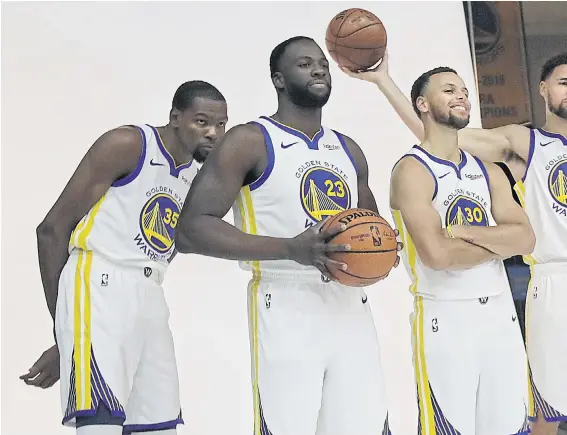  ??  ?? Warriors players, from left, Kevin Durant, Draymond Green, Stephen Curry, Klay Thompson and DeMarcus Cousins pose during a photo session ahead of the new season.