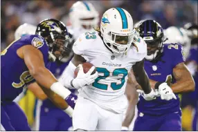  ?? Associated Press photo ?? Miami Dolphins running back Jay Ajayi (23) rushes the ball in an NFL football game against the Baltimore Ravens last week in Baltimore. Ajayi was traded to Philadelph­ia on Tuesday.