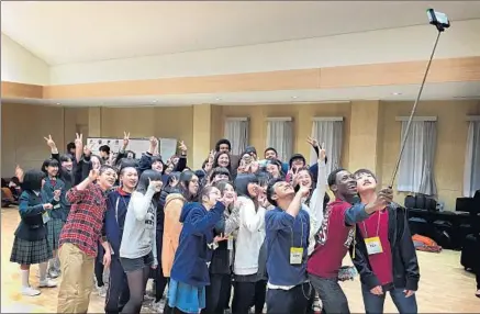  ?? Brian Lauritzen ?? YOLA PERFORMER Daniel Egwurube, 17, holds a selfie stick to capture a photo with newly made friends in Soma, Japan.