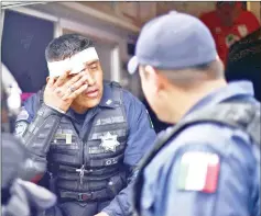  ??  ?? A Mexican Federal Police officer is pictured after being injured during a scuffle with Honduran migrants.