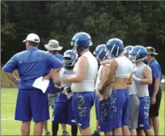  ?? ALEX FARRER / staff ?? Gordon Central head coach David Humphreys (left) talks with his offense in the huddle during a recent preseason practice.