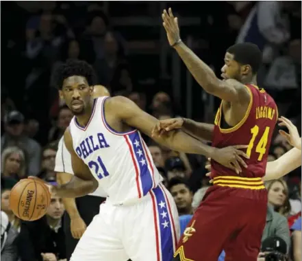  ?? MATT SLOCUM — THE ASSOCIATED PRESS ?? Joel Embiid, left, tries to get around Cleveland Cavaliers’ DeAndre Liggins, center, and Kevin Love on Sunday.