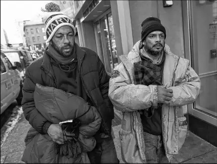  ?? AP Photo ?? Homeless men Sean Stuart, left, and Segundo Rivera walk on a street after spending the day at St. Francis House in Boston. With temperatur­es across Massachuse­tts not expected to rise above freezing for days, politician­s and advocates for the homeless...