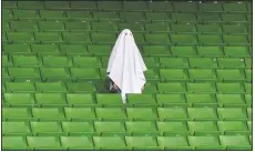  ?? (File Photo/AP/Kerstin Joensson) ?? A man dressed as a ghost stands on the empty tribune on March 12, 2020, prior the Europa League round of 16 first leg soccer match between Linzer ASK and Manchester United in Linz, Austria. The match was being played in an empty stadium because of the coronaviru­s outbreak.