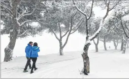  ??  ?? People take a walk on a snow-covered path by the road called route de la Gineste, connecting Marseille and Cassis, on Saturday, Marseille, southern France. AFP