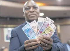  ?? ?? LOADSAMONE­Y: John Mushayavan­hu, governor of Zimbabwe’s central bank, holds up the new ZIG currency unit in Harare, Zimbabwe, on Friday.