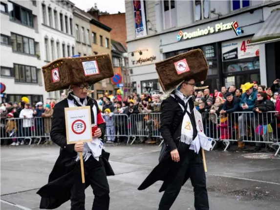  ??  ?? ‘Hateful’: carnivalgo­ers dressed in oversized Jewish hats hold signs criticisin­g Unesco ‘censorship’ of their costumes (AFP/Getty)