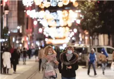  ?? AP ?? People, wearing masks to help curb the spread of the coronaviru­s, walk along Istiklal Street, the main shopping street in Istanbul, late Wednesday.