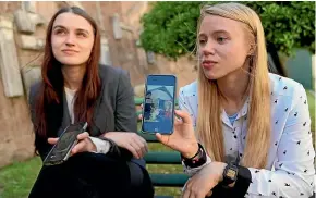  ?? ?? Kateryna Prokopenko, wife of Denys Prokopenko, commander of the Azov regiment, right, and Yulia Fedosiuk, wife of Arseny Fedosiuk, another member of Azov regiment, show photograph­s on their phones of their husbands, who are defending the Azovstal steel plant in Mariupol. The women are calling for any evacuation of civilians to also include soldiers.