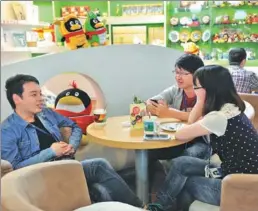  ?? YU GE / FOR CHINA DAILY ?? Visitors talk at Tencent’s image product shop in Shenzhen, Guangdong province.