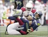  ?? ?? Russell Wilson of the Seahawks is sacked by the Cardinals’ Chandler Jones (bottom) as Markus Golden moves in on top during the second half.