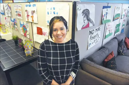  ?? Darrell Sapp/Post-Gazette ?? Rosamaria Cristello, director of the Latino Family Center in Hazelwood, was chosen to receive the Barbara McNees Spirit of Athena Scholarshi­p. Behind her is art created by children at the center.