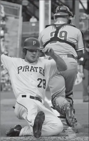  ?? The Associated Press ?? HOMEWARD BOUND: Pittsburgh Pirates’ John Jaso (28) slides past Philadelph­ia Phillies catcher Cameron Rupp (29) to score the second of two runs on a double by Francisco Cervelli in the sixth inning of a 6-3 win Saturday in Pittsburgh.