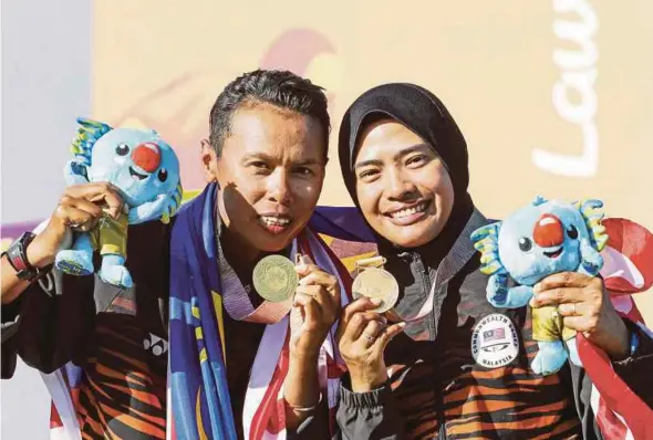  ??  ?? Siti Zalina Ahmad (left) and Emma Firyana Saroji celebrate winning gold in the women’s pairs at the Commonweal­th Games yesterday.