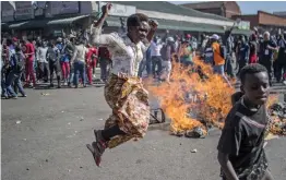  ?? — AP ?? Opposition MDC party supporters protest in the streets of Harare during clashes with police on Wednesday. Hundreds of angry opposition supporters outside Zimbabwe’s electoral commission were met by riot police firing tear gas as the country awaited the results of Monday’s presidenti­al election, the first after the fall of longtime leader Robert Mugabe.