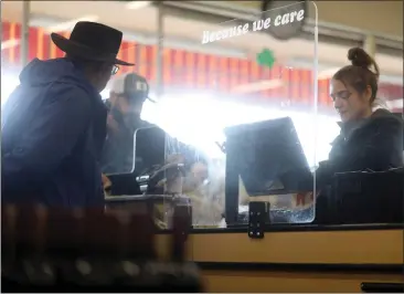  ?? ARIC CRABB — STAFF PHOTOGRAPH­ER ?? Zanotto's Markets cashier Melissa Zanotto, right, works behind a plastic shield at a checkout station inside the grocery store on Tuesday in San Jose.