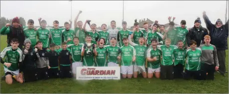  ??  ?? The Naomh Eanna squad singing in the rain after completing the double-double in Enniscorth­y on Saturday.