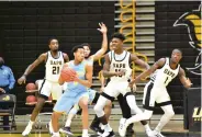  ?? (Pine Bluff Commercial/I.C. Murrell) ?? Jayden Saddler (5) of Southern University faces defensive pressure from Shaun Doss Jr. (21), Alvin Stredic Jr. (15) and Jalen Lynn (1) of the University of Arkansas at Pine Bluff during the second half on Feb. 13 at H.O. Clemmons Arena.