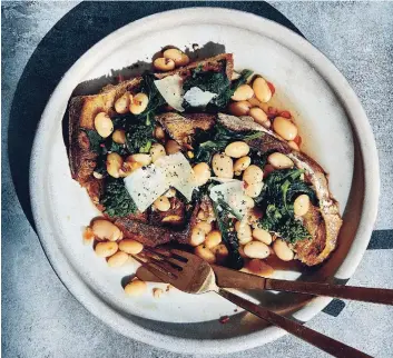  ?? COURTESY OF TEN SPEED PRESS ?? Garlicky great northern beans and broccoli rabe over toast, excerpted from “Cool Beans” by Joe Yonan, make a satisfying family meal.